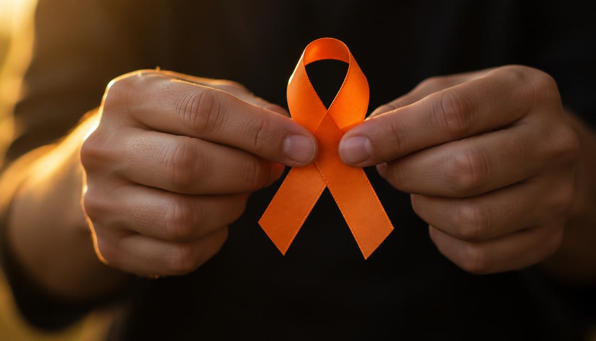 أيدي تمسك شريطًا برتقاليًا، رمز حملة الأمم المتحدة Orange the World